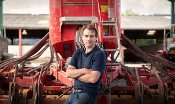 Farmer Joe Dugdale leaning against some farm machinery